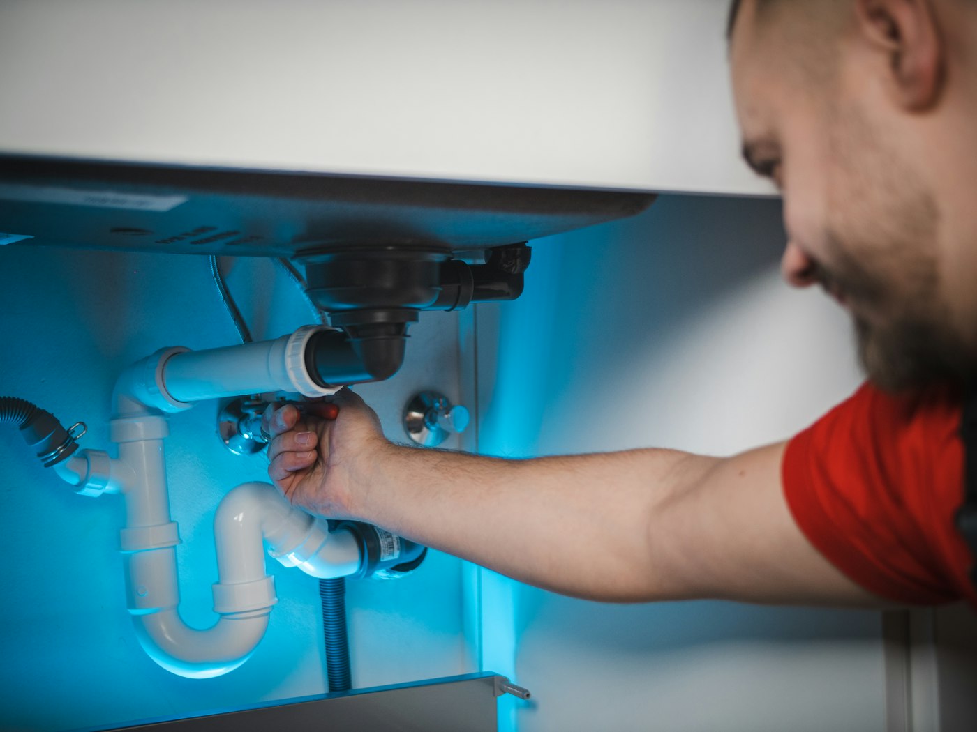 Artisan plombier intervenant sur une installation, vue réaliste chantier